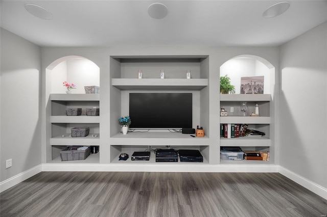 living area with built in shelves, baseboards, and wood finished floors