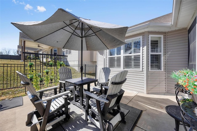 view of patio featuring ceiling fan and fence