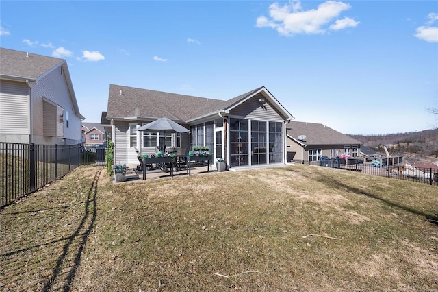 rear view of property with a sunroom, a patio, and a lawn