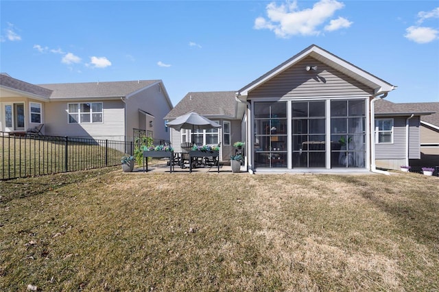 rear view of house featuring a patio, a lawn, fence, and a sunroom