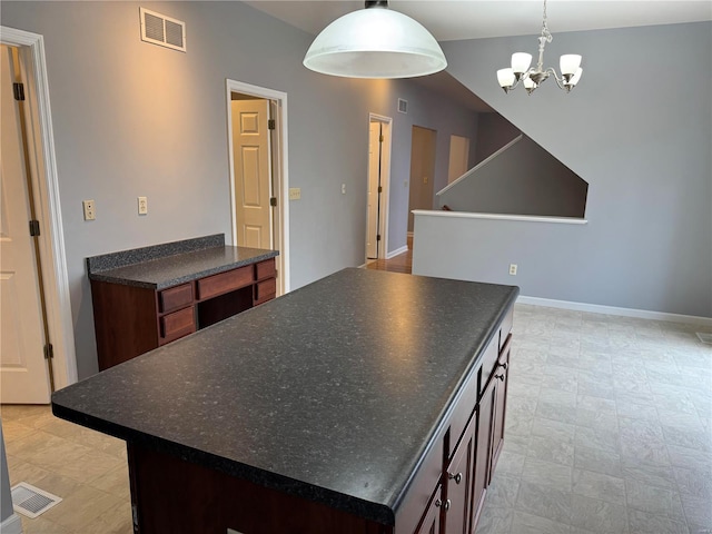 kitchen with dark brown cabinetry, hanging light fixtures, a notable chandelier, and a kitchen island