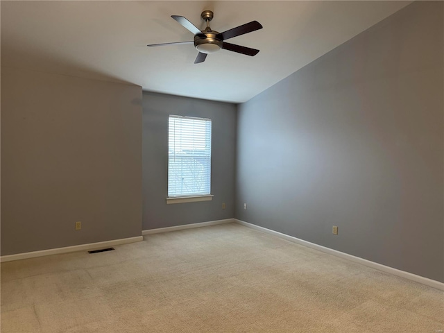 spare room featuring light colored carpet and ceiling fan