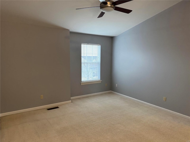 empty room featuring ceiling fan and light colored carpet