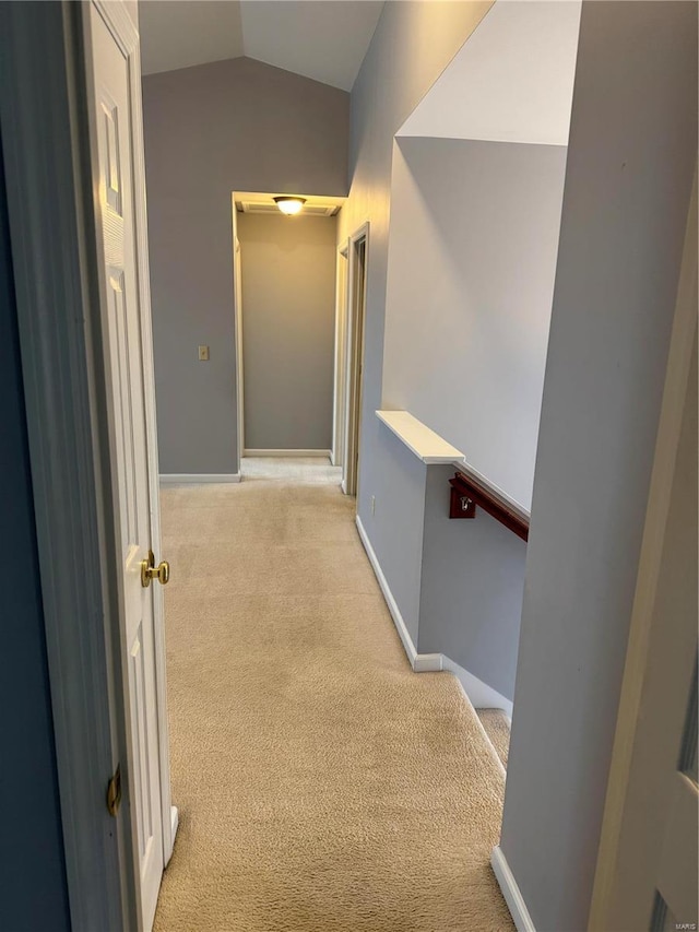 corridor featuring vaulted ceiling and light carpet