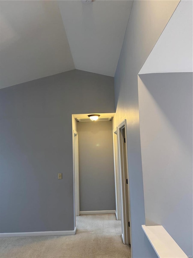 hall featuring light carpet and lofted ceiling