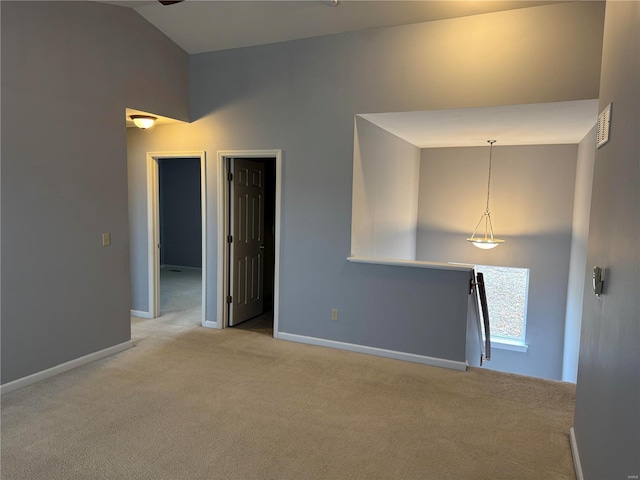 empty room featuring light carpet and high vaulted ceiling