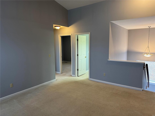 unfurnished room featuring light colored carpet and a high ceiling