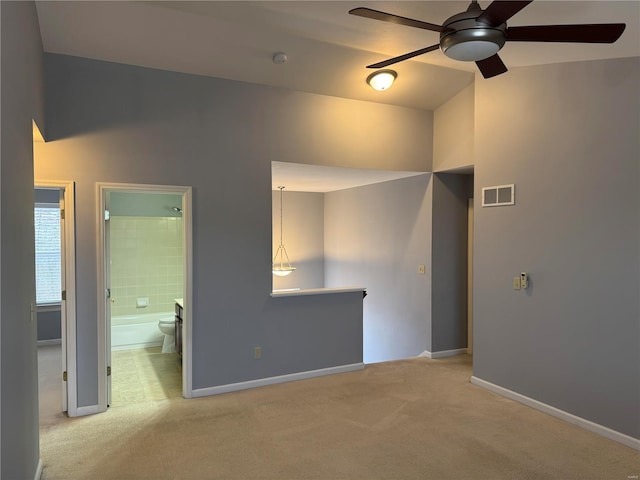 interior space with ceiling fan, lofted ceiling, and light carpet