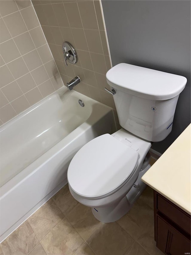 full bathroom featuring tiled shower / bath, vanity, tile patterned floors, and toilet