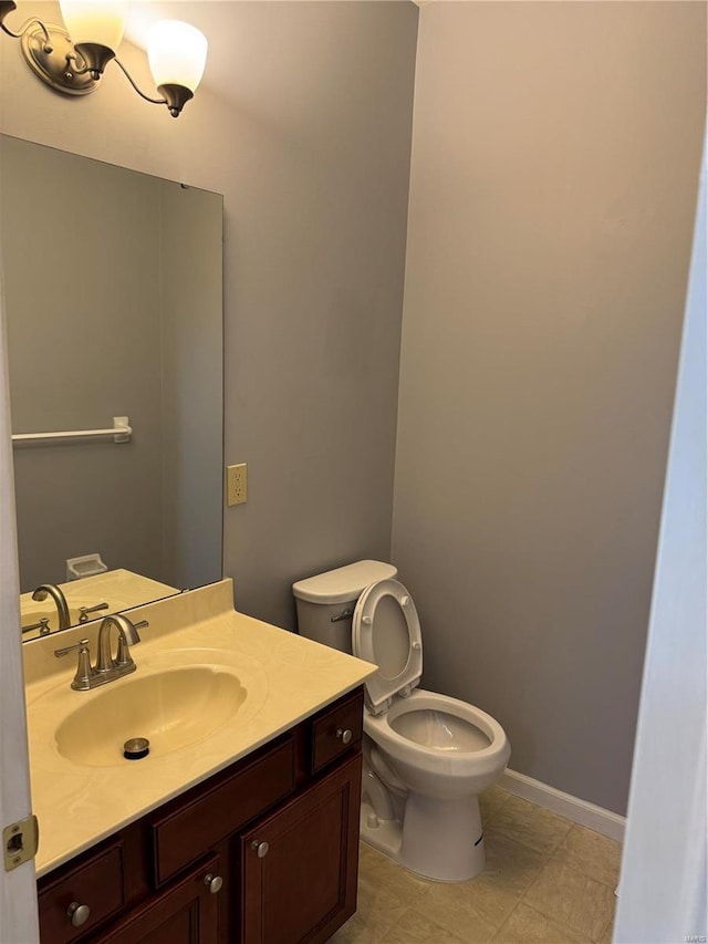 bathroom with vanity, toilet, and baseboards