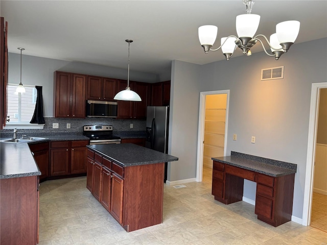 kitchen featuring a sink, visible vents, appliances with stainless steel finishes, a center island, and dark countertops