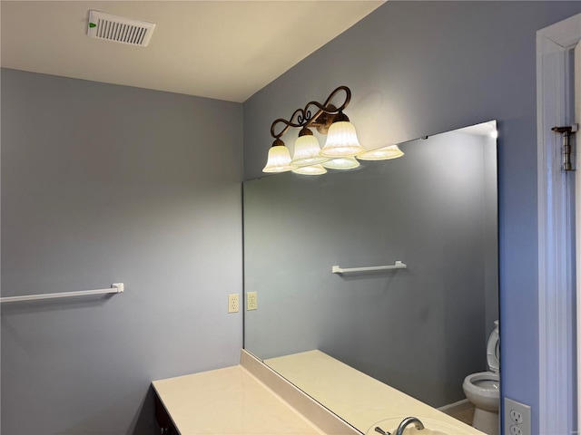 bathroom with toilet, visible vents, and vanity