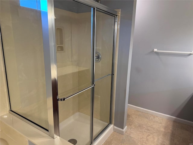 bathroom featuring a stall shower and baseboards