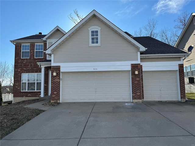 traditional home with a garage, roof with shingles, concrete driveway, and brick siding