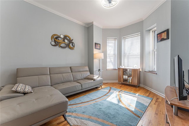 living area featuring baseboards, wood finished floors, and crown molding