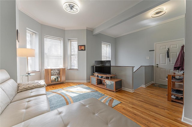 living area with ornamental molding, beamed ceiling, baseboards, and wood finished floors