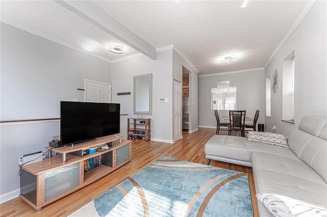 living room with ornamental molding, wood finished floors, and baseboards