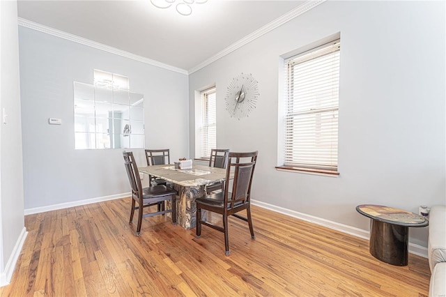 dining area featuring a healthy amount of sunlight, baseboards, ornamental molding, and wood finished floors