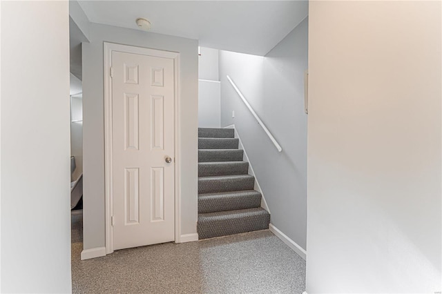 stairs featuring speckled floor and baseboards