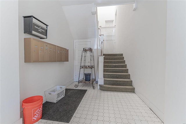 stairs featuring mail area, baseboards, and tile patterned floors