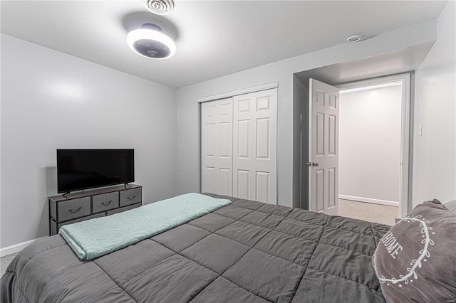 bedroom with carpet floors, a closet, visible vents, and baseboards