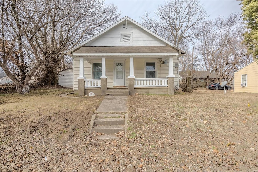 bungalow-style home featuring a porch and a front yard