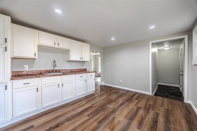 kitchen with sink, dark wood-type flooring, and white cabinets