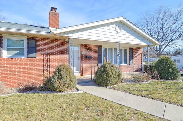 bungalow-style home with a front yard and covered porch