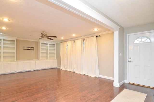 entryway with ornamental molding, dark wood-type flooring, and ceiling fan