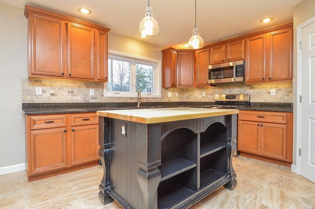 kitchen featuring appliances with stainless steel finishes, a center island, sink, and backsplash