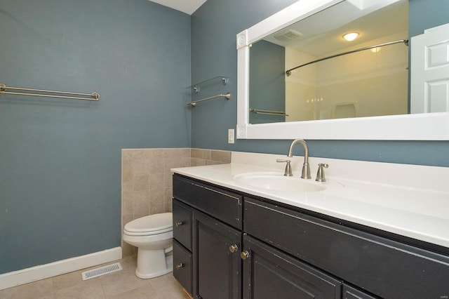 bathroom with tile patterned flooring, vanity, toilet, and walk in shower