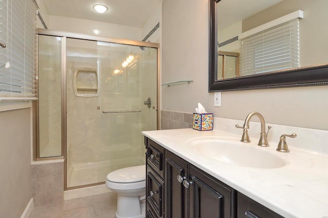 bathroom featuring vanity, tile patterned flooring, a shower with shower door, and toilet