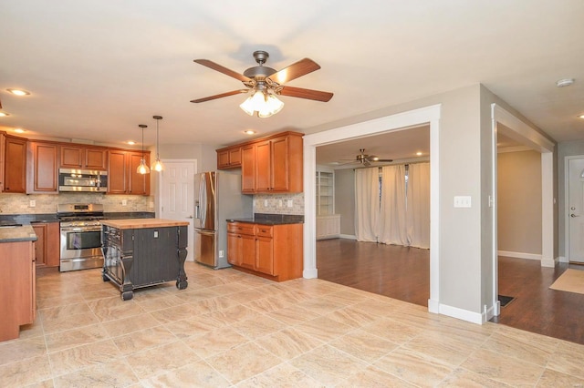 kitchen with a kitchen island, decorative light fixtures, backsplash, a kitchen breakfast bar, and stainless steel appliances