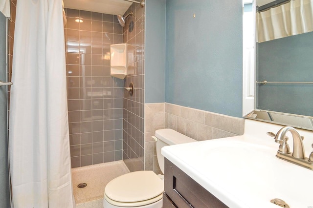 bathroom with vanity, curtained shower, tile walls, and toilet