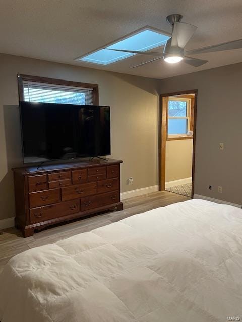 unfurnished bedroom featuring multiple windows, a skylight, and ceiling fan