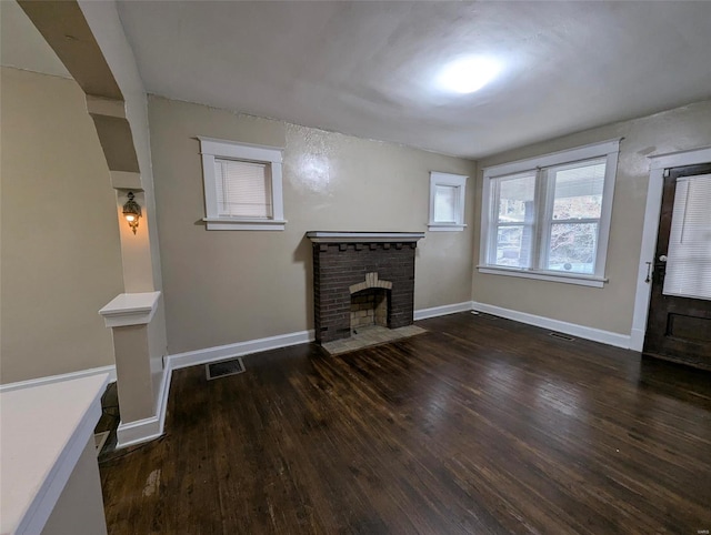 living room with dark wood-type flooring and a fireplace