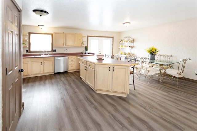 kitchen with a kitchen island, wood-type flooring, sink, a breakfast bar area, and stainless steel dishwasher