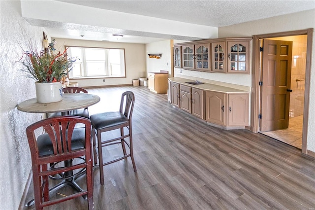 dining room with sink, hardwood / wood-style floors, and a textured ceiling