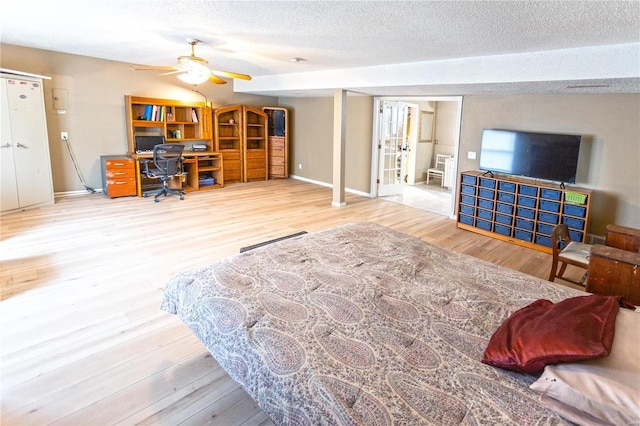 interior space featuring ceiling fan, wood-type flooring, and a textured ceiling