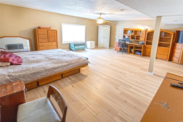 bedroom featuring wood-type flooring, ceiling fan, and a textured ceiling