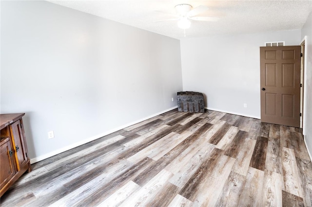 spare room with ceiling fan, wood-type flooring, and a textured ceiling