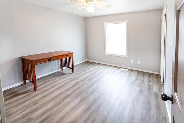 empty room featuring ceiling fan and light hardwood / wood-style flooring