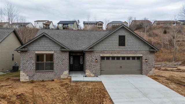 view of front of home with central AC and a garage