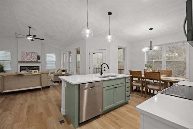 kitchen with pendant lighting, sink, stainless steel dishwasher, and a kitchen island with sink