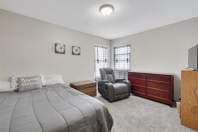 bedroom featuring a textured ceiling and light colored carpet