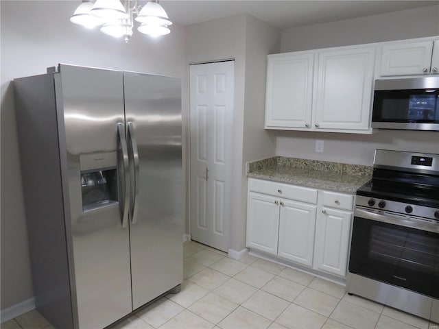 kitchen with white cabinetry, light tile patterned floors, pendant lighting, and appliances with stainless steel finishes