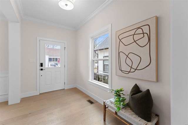 foyer featuring baseboards, ornamental molding, visible vents, and light wood-style floors