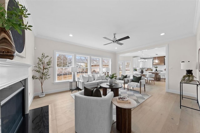 living room featuring light wood finished floors, ornamental molding, a fireplace, and baseboards