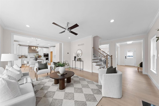 living area featuring light wood-style floors, stairs, ornamental molding, and recessed lighting