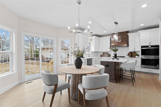 dining room with light wood-style floors, recessed lighting, visible vents, and baseboards